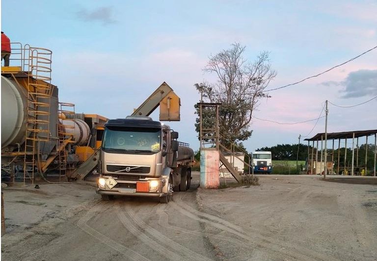 Usina de asfalto com chaminés e operação ativa